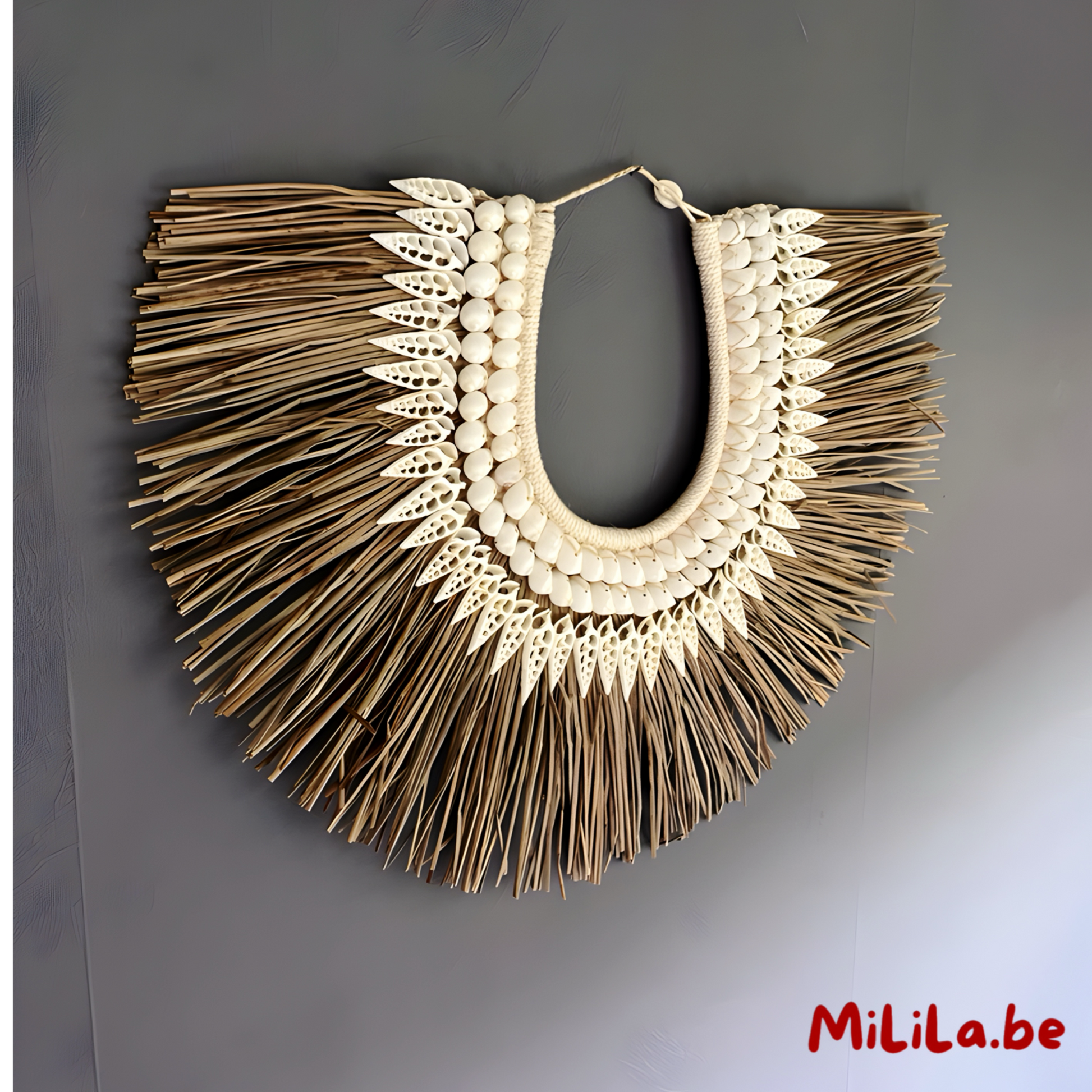 Bohemian wanddecoratie van schelpen en grasvezels in een neutraal interieur