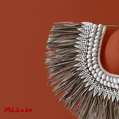 Detail van schelpen en gedroogd tropisch gras in de handgeweven wanddecoratie